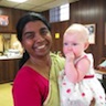 Photo of Matushka Suja holding one of the babies of the parish