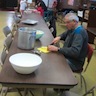 Photo of a parishioner cutting up vegetables for the soup