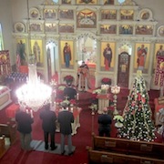 Photo of Father Theopahn reading the Gospel