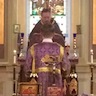 Photo of Father Daniel Kovalak reading the Gospel