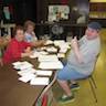 Photo of parishioners writing out Nativity Cards to all 100+ residents at Serenity Gardens, parishioners unable to attend services, and friends of the parish.