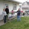 Photo of parishioners decorating the outside of the rectory for Christmas.