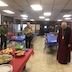 Photo of Bishop Mark leading the prayer at the St Michael's Day luncheon. Six guests are also shown.