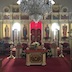 A wide-angle, landscape-mode photo of the altar, with poinsettias spaced across the front of the altar and on the three steps. There's also a decorated tree to the right.