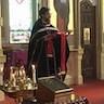 Fr. Vjekoslav stands at the front of the alter and is reading from the bible during holy_week