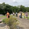 Photo of Father Vjekoslav blessing a gravesite at St. Michael's Cemetary. A small crowd stands behind him