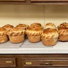 Photo of two rows of freshly baked pascha breads on the counter in the hall kitchen.