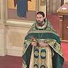 Photo of Father Vjekoslav, wearing green vestments, is standing in front of the iconostas, speaking to the congregation.