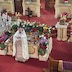 Photo of Fr. Barnabas addresses the congregation while standing in front of the Epitaphios (tomb icon), which surrounded by flowers.
