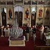 Photo of candlebearers waiting near the back side of the Epitaphios (tomb icon), which is surrounded by flowers, on Holy Saturday.