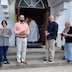 Photo of four males standing outside at the front of the church as Fr. Barnabas walks back inside. Another man is standing at the side of the doorway as Fr. Barnabas passes by.