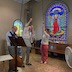 Photo two men and a woman in the choir loft. Each is pulling on a rope to ring the church bells during the Pascha Liturgy service.