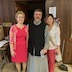 Fr. Barnabas poses with two female parishoners in the church hall.