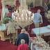 View fromm the choir loft as parishoners walk up to the front of the church to kiss the cross and receive a blessing. As they walk forward, they file past a table covered with a white table cloth Paska breads.