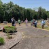 A wide-angle view of Fr. Barnabas and parishioners standing outside at St. Michael's cemetery while Fr. Barnabas blesses the graves.