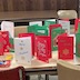 Photo a table in the church hall. The table is covered by handmade Christmas cards, which are mostly red or green, but there are also white and blue cards. A pack of Crayola markers and a bottle of glue are also on the table.