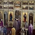 View of the iconostasis with four clergy members and an altar boy waling towards the Royal Doors. The clergy members are wearing purple vestments, and the altar boy is wearing a gold vestment.
