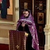 Photo of Fr. Kirill standing at a lecturn in front of the Royal Doors and delivering a sermon. In the moment captured, he's looking towards the lecturn, and his hands are clasped in front of him.