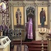 Fr. Kirill is standing in front of the iconostasis and blessing the church. In the moment captured in the photo, he standing in front of the left side-door, between St. Innocent and the Virgin Mary holding the baby Jesus. He's facing left-frame, and his censor is catch mid-air in front of St. Innocent.