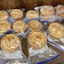 Eleven paska breads sealed in zippered, plastic bags that have a blue-purple zipper.